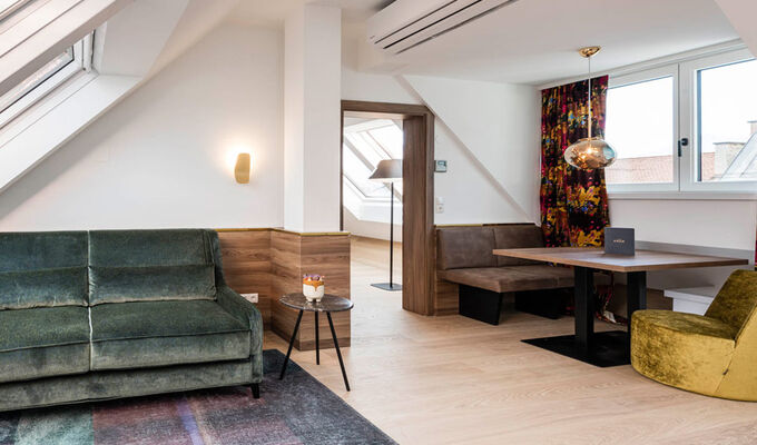 View into the Panorama Apartment 2: table with seating, couch and door to the bedroom