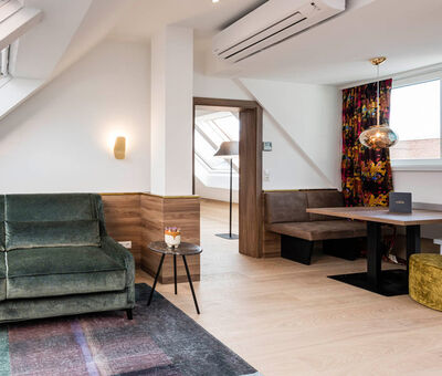 View into the Panorama Apartment 2: table with seating, couch and door to the bedroom