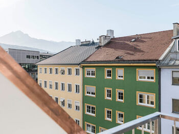 Balcony-view of Panorama Suite. You can see roofs of houses, in the background the mountain range in Innsbruck