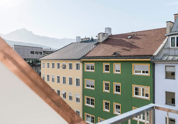 Balcony-view of Panorama Suite. You can see roofs of houses, in the background the mountain range in Innsbruck