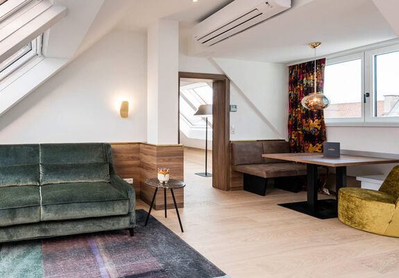 View into the Panorama Apartment 2: table with seating, couch and door to the bedroom